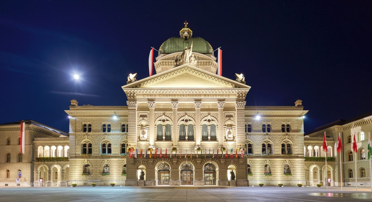 Swiss federal parliament building in Bern with national flags