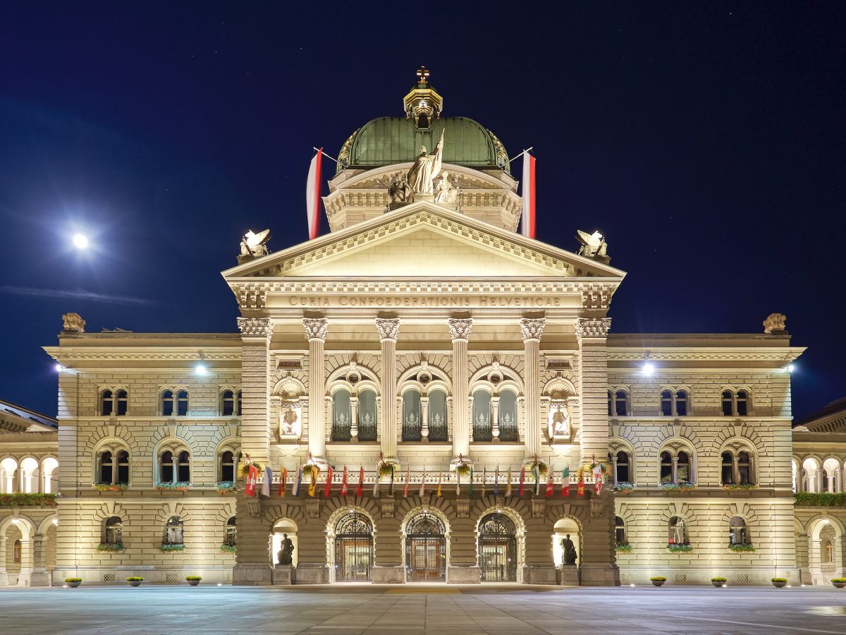 Swiss federal parliament building in Bern with national flags