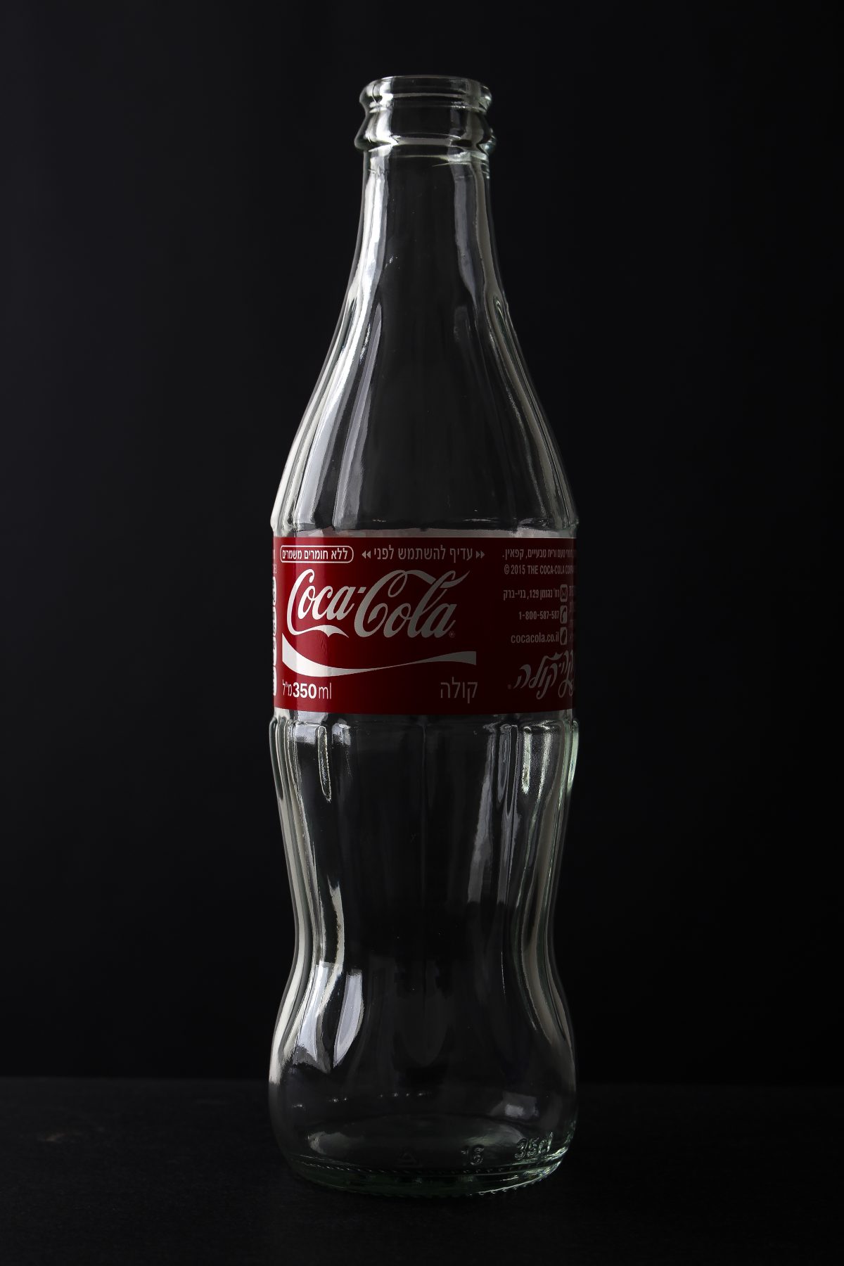 Coca-Cola glass bottles on a supermarket shelf