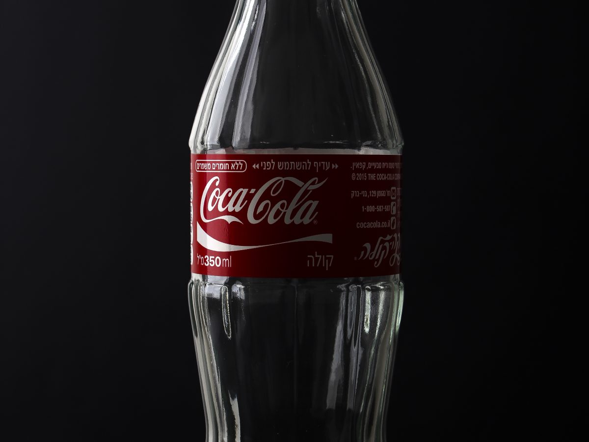 Coca-Cola glass bottles on a supermarket shelf