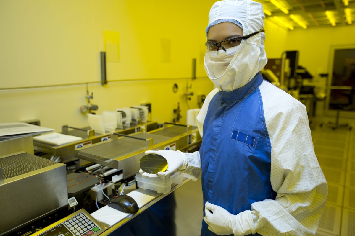 Researcher holding a silicon wafer in a semiconductor laboratory
