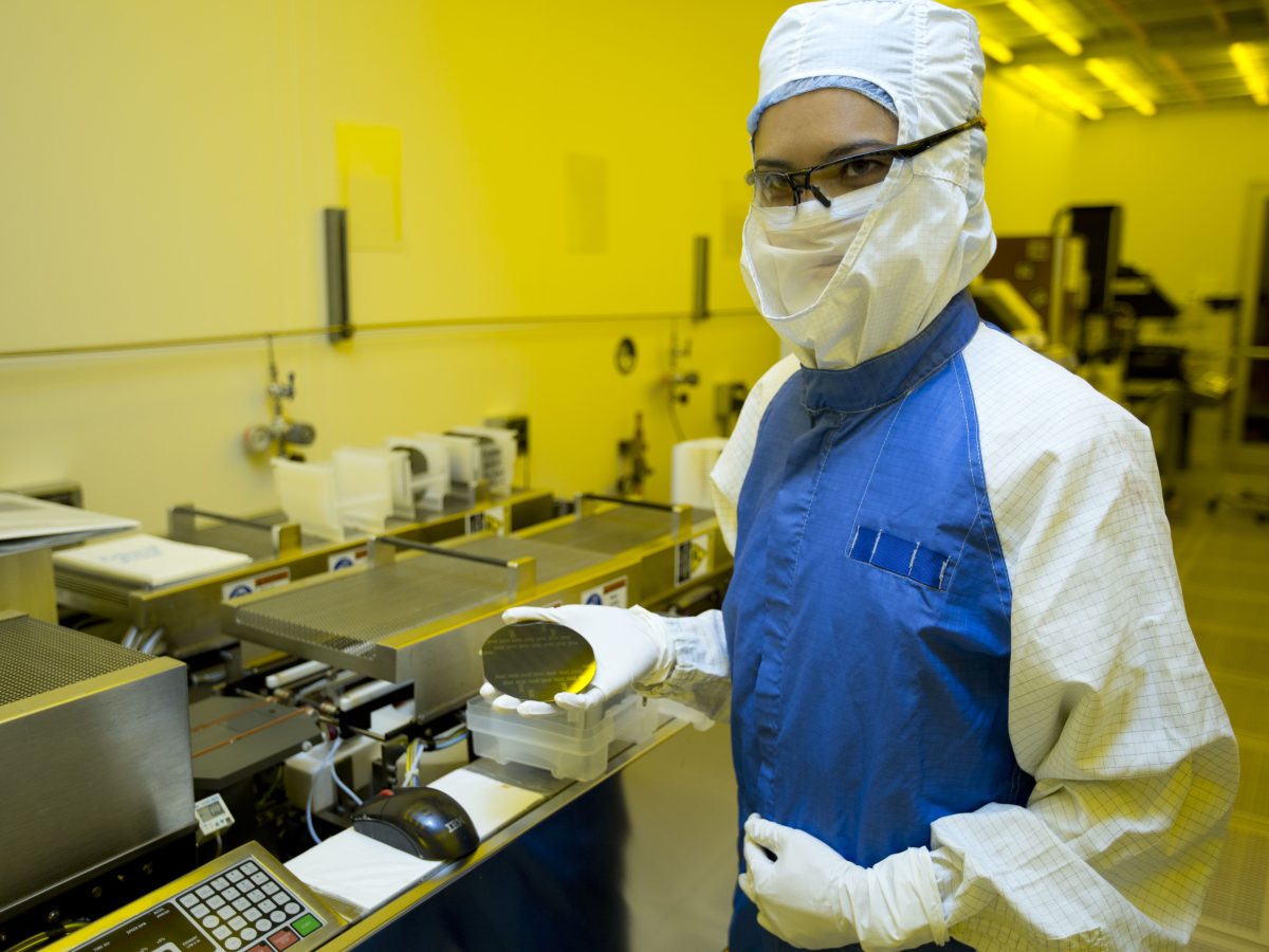 Researcher holding a silicon wafer in a semiconductor laboratory