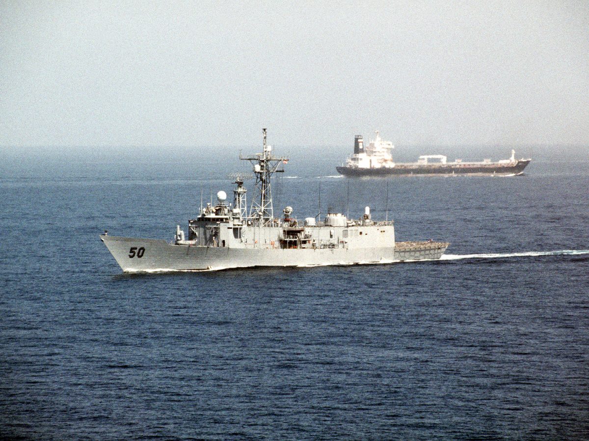 USS Taylor guided missile frigate passes a tanker in the Strait of Hormuz during Operation Desert Shield