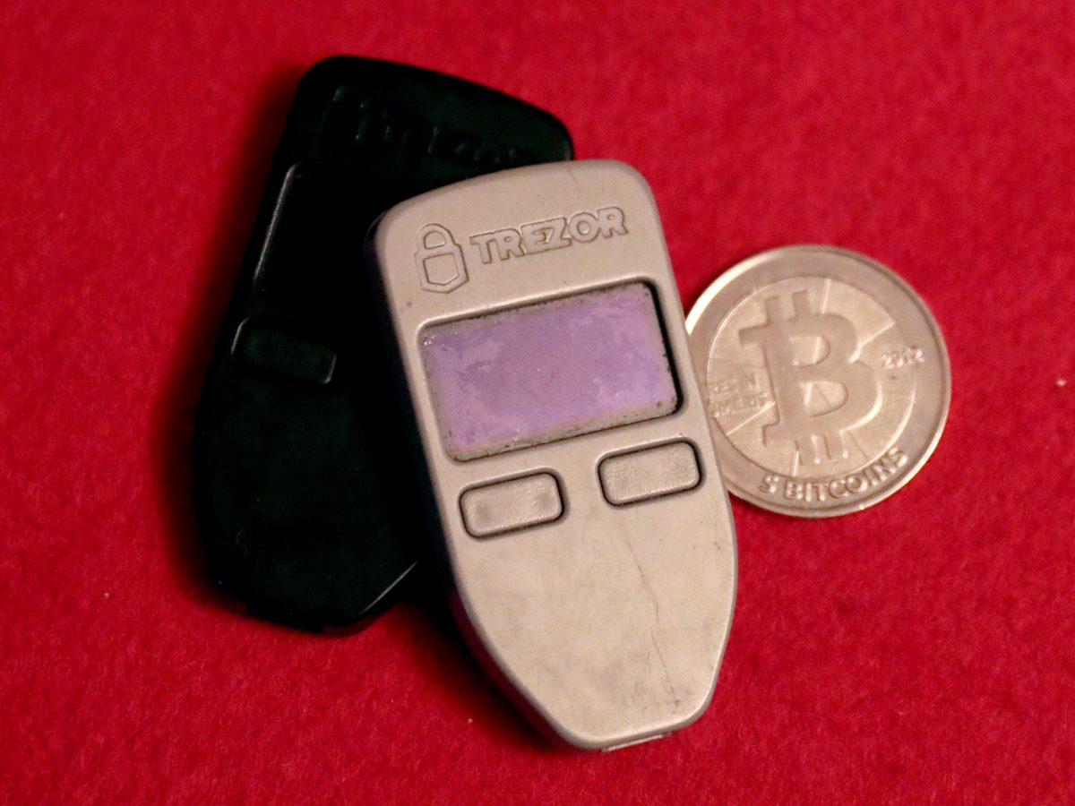Two Trezor One bitcoin hardware wallets and a Casascius physical bitcoin coin