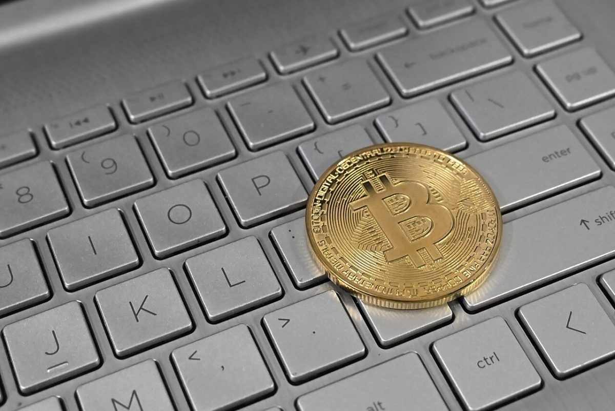 Bitcoin cryptocurrency coin placed on a laptop keyboard, representing digital asset trading